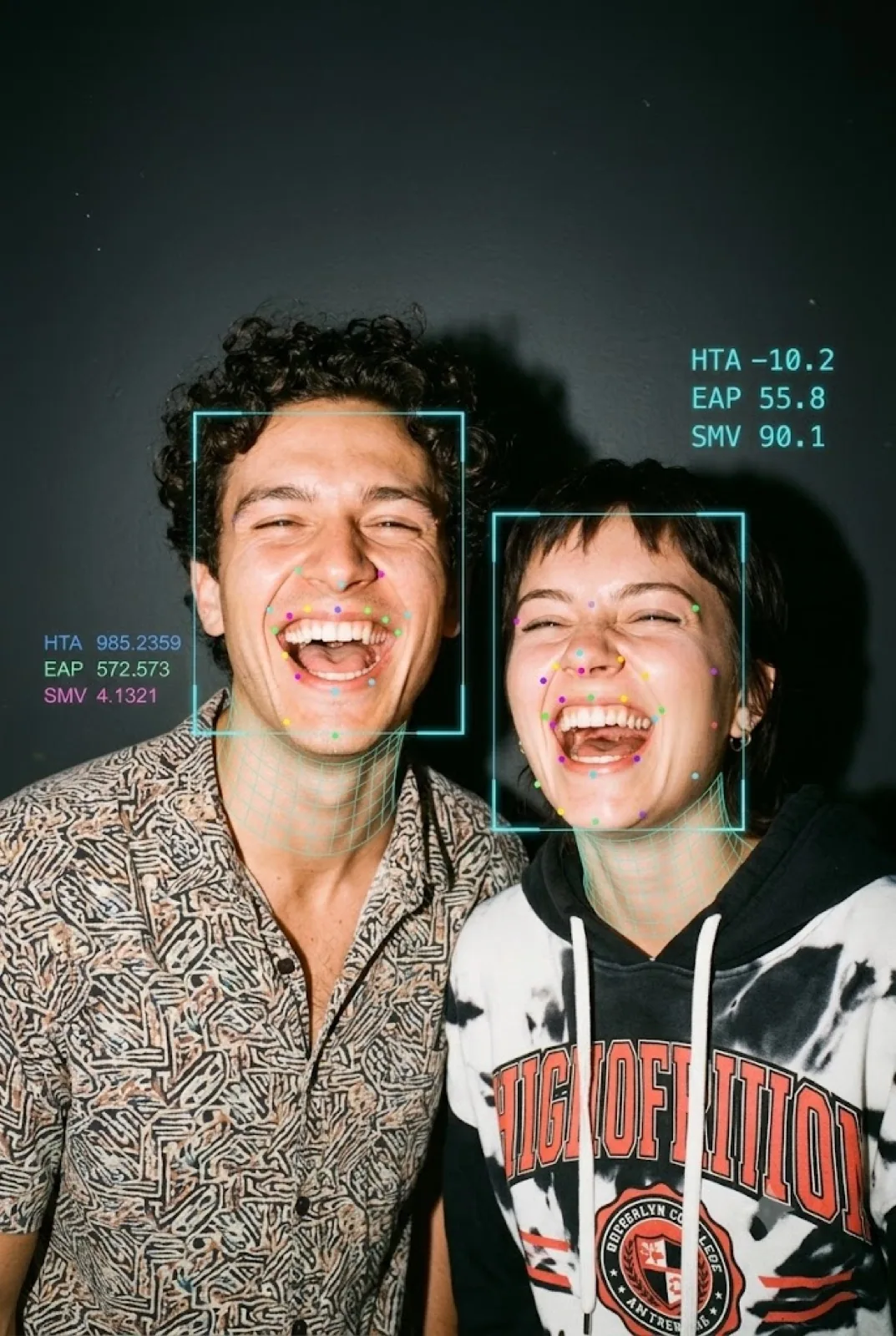 Two friends laughing as the machine tries to score them.